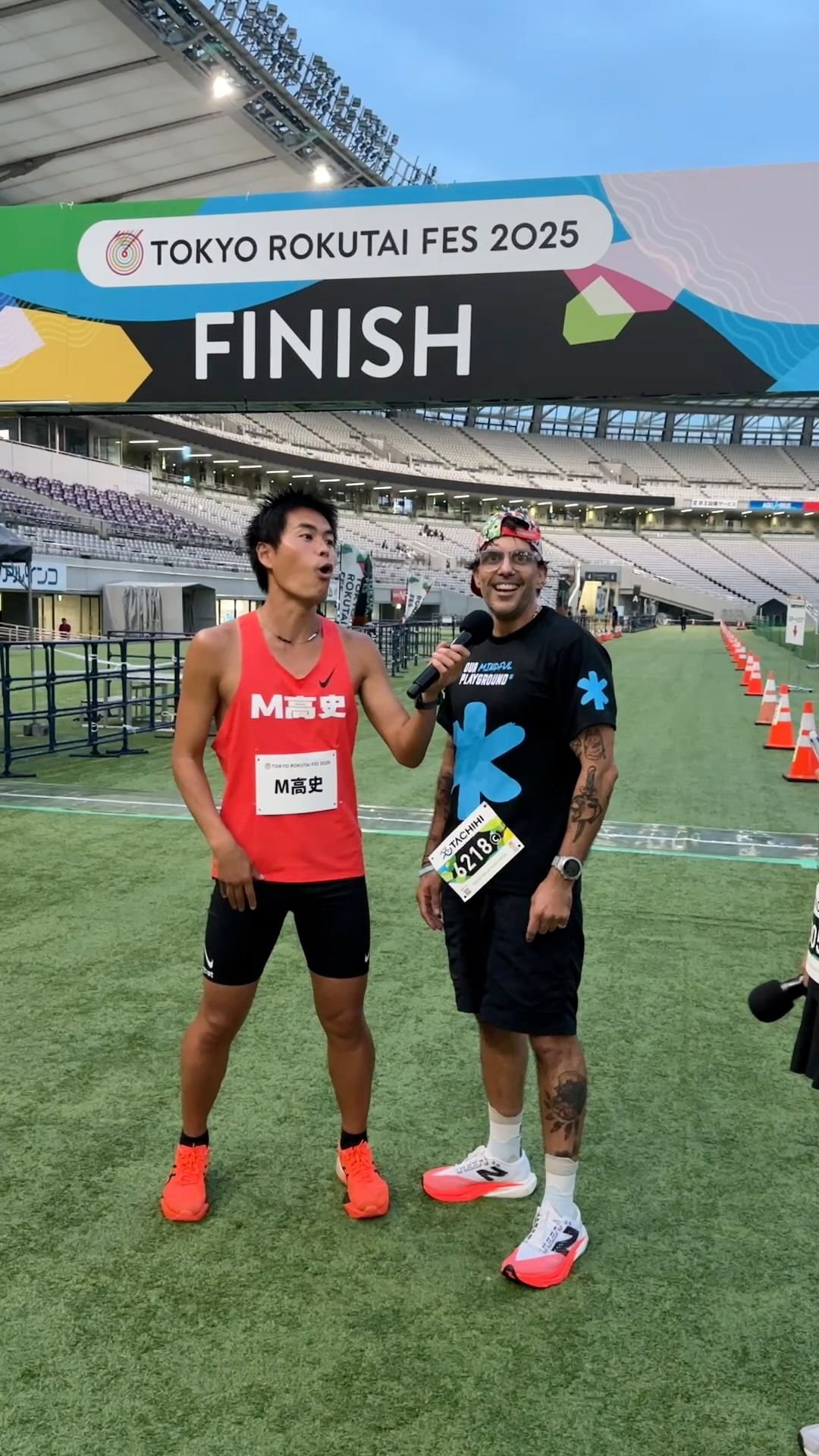 Todd Foxx with running comedian M Takashi beneath the Tokyo Rokutai Fes 2025 finish arch