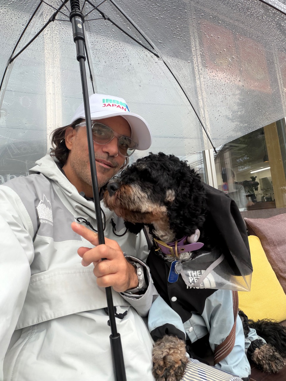 Jordan leaning affectionately towards Todd Foxx beneath an umbrella